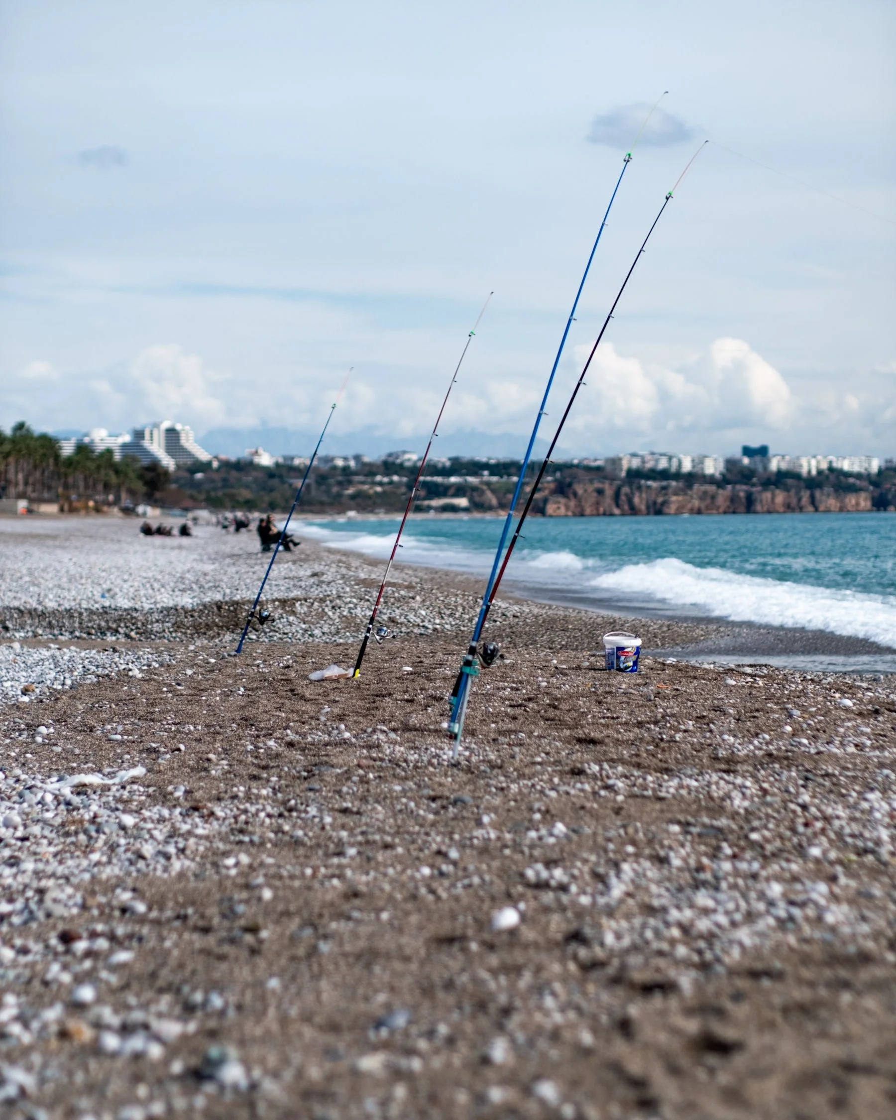 Fishing rods set beside a pebbled sea shore