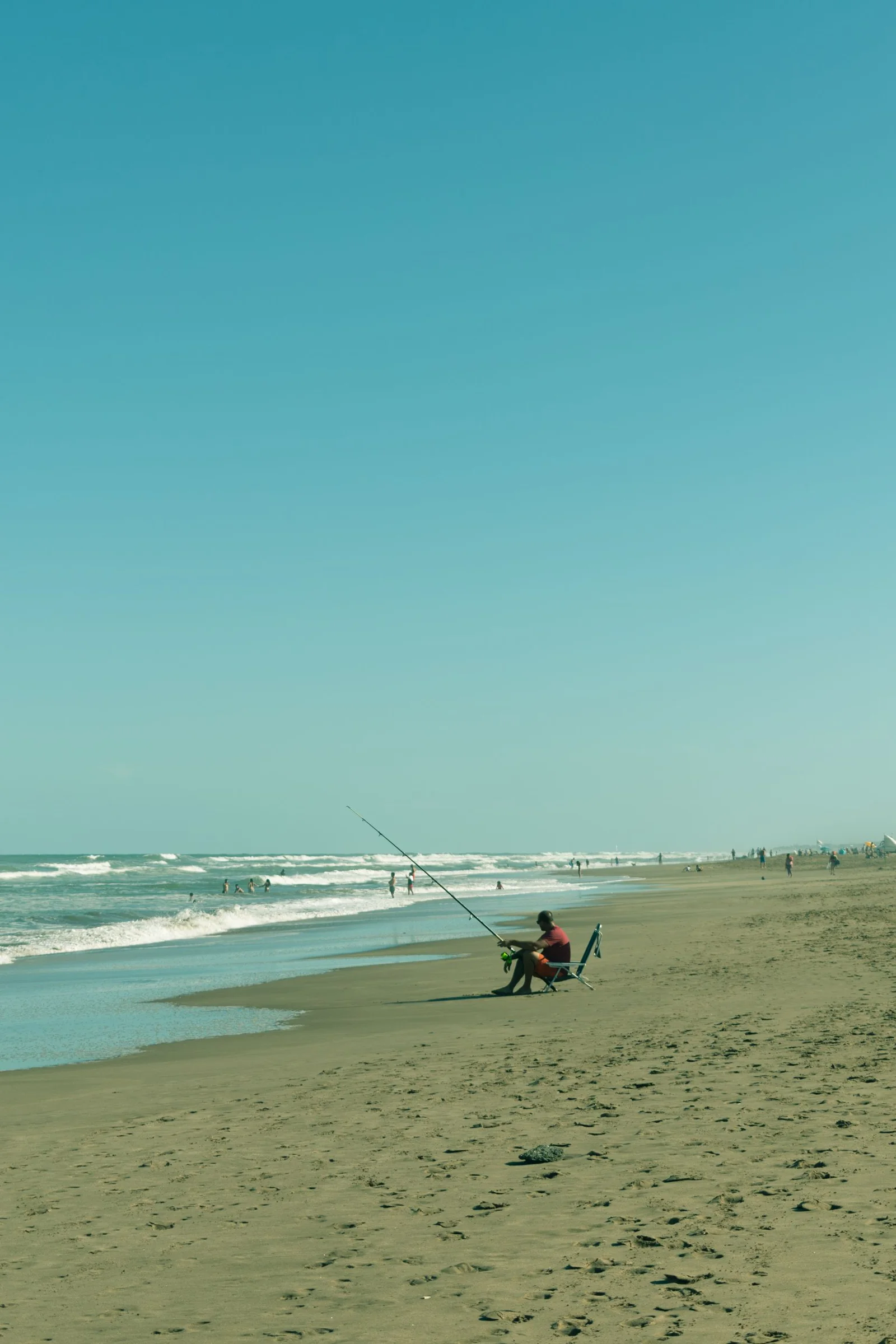 A beach angler beside fishing rods